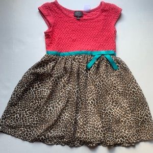 A pink dress with leopard print and a blue bow